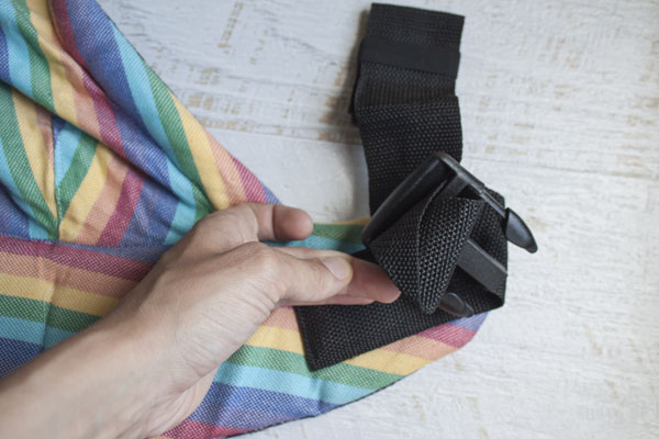 Holding the strap folded, pull it through one click slot, then through the other.