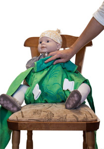 spread the fabric so as to pass the carrier back between the baby legs and lift it to its chest